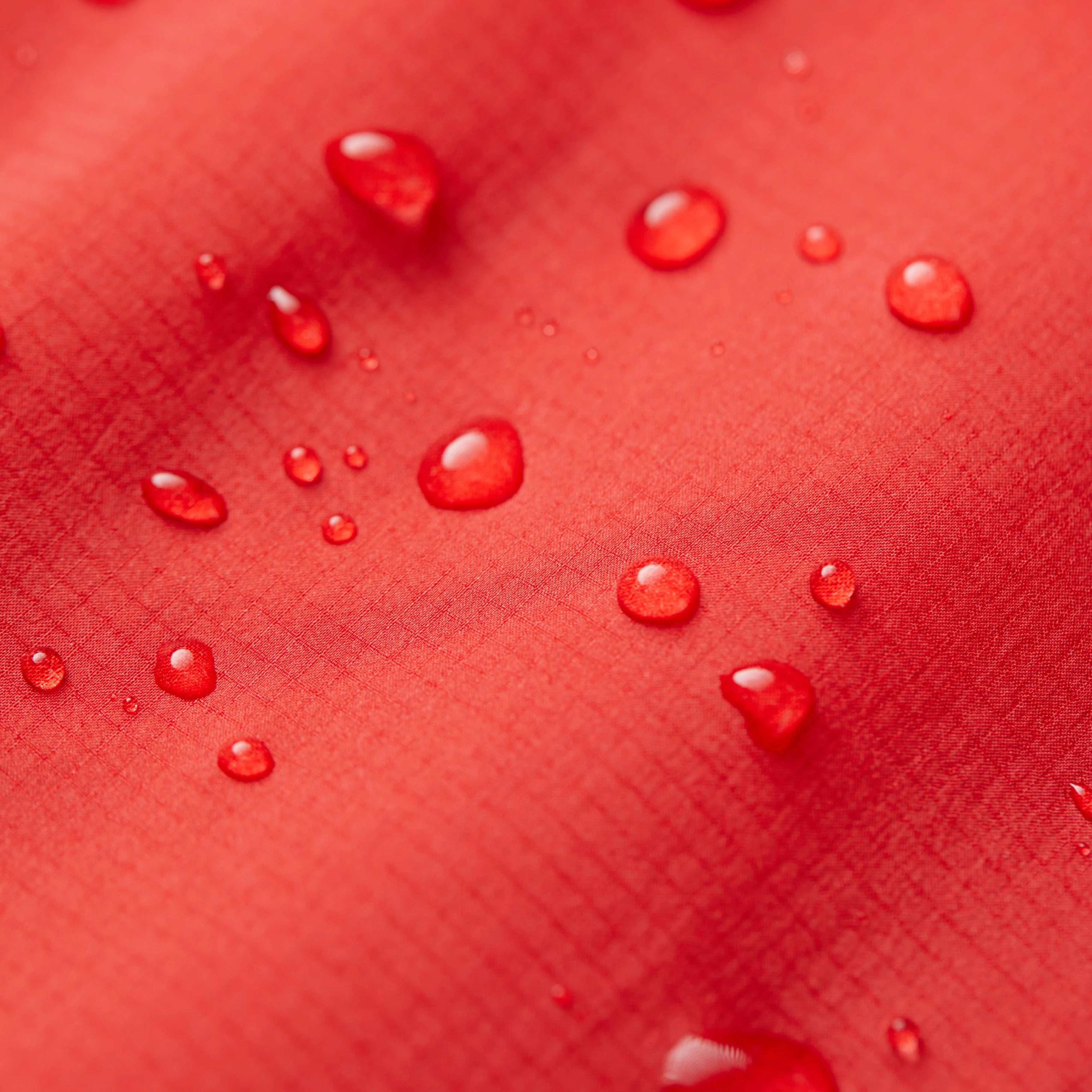 Water droplets on a red textured surface